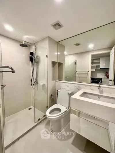 Modern bathroom with glass shower and sleek fixtures in a contemporary apartment.
