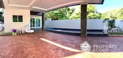 Spacious outdoor patio with pool and garden view, perfect for relaxation and entertainment.