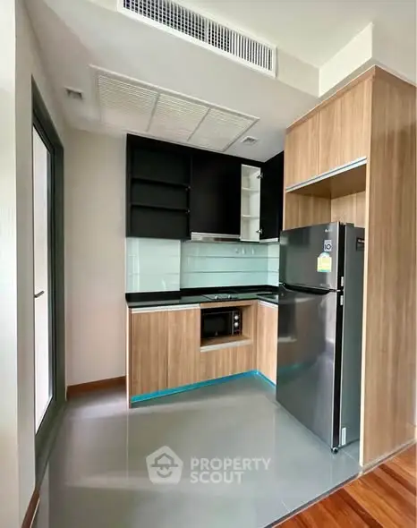 Modern compact kitchen with sleek appliances and wooden cabinetry