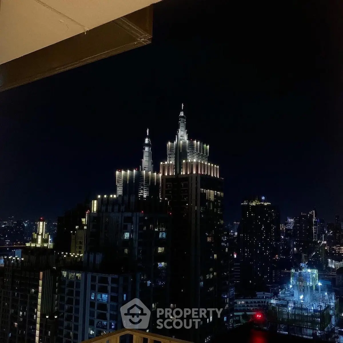 Stunning night view of illuminated city skyscrapers from a high-rise balcony.