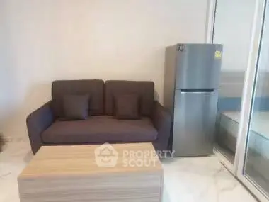 Modern living room with sleek sofa and stainless steel fridge