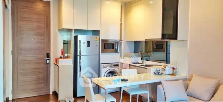 Modern kitchen with integrated appliances and cozy dining area in stylish apartment.