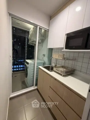 Modern kitchen with sleek cabinetry and integrated appliances in a compact layout.