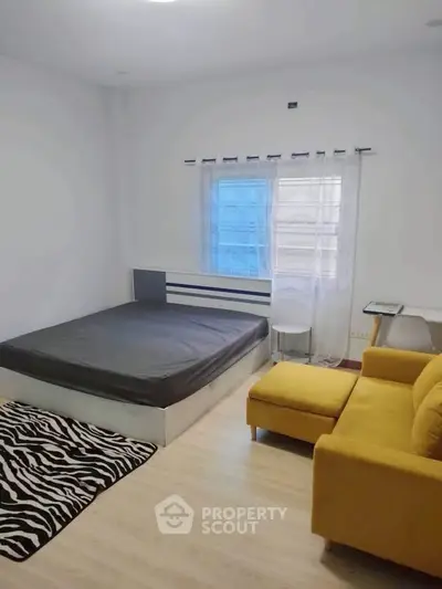 Modern bedroom with stylish yellow sofa and zebra rug, perfect for cozy living.