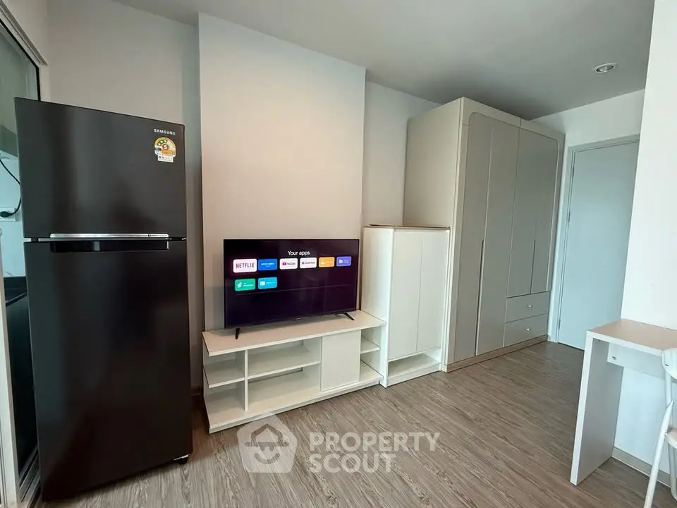 Modern living room with sleek furniture and smart TV, featuring a spacious wardrobe and contemporary design.