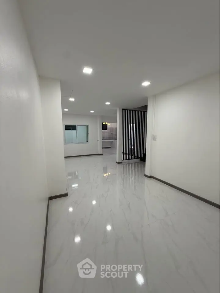 Spacious modern interior with sleek marble flooring and recessed lighting, ideal for contemporary living.