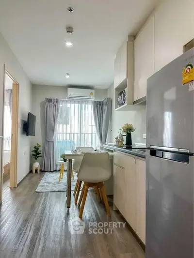 Modern kitchen with sleek design and open layout, featuring dining area and natural light.