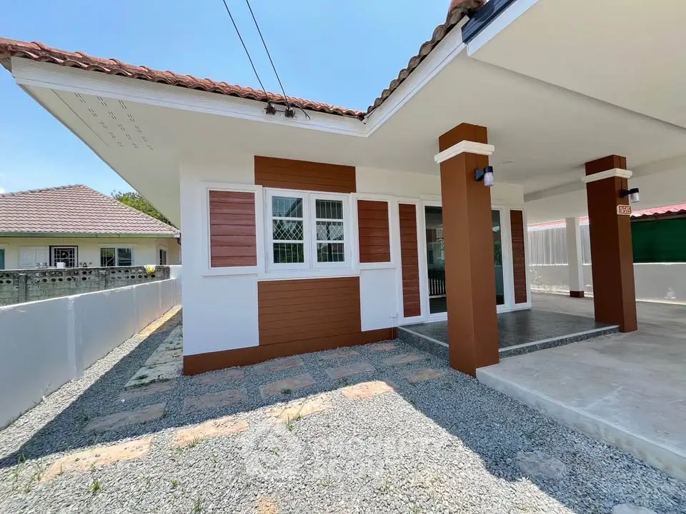 Charming single-story house with modern exterior and spacious driveway in a serene neighborhood.