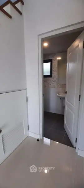 Modern bathroom entrance with sleek tile flooring and contemporary design.