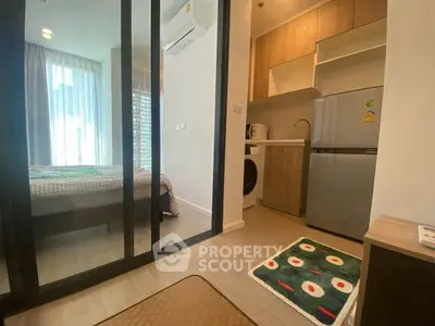 Modern studio apartment with compact kitchen and cozy bedroom, ideal for urban living.