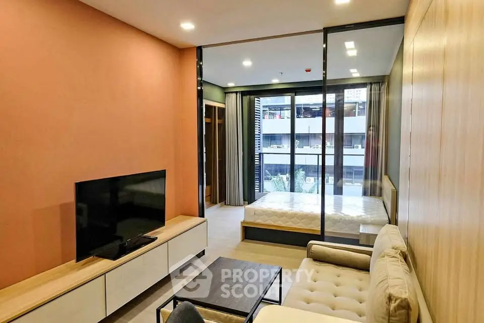 Modern studio apartment with stylish living area and large window view.