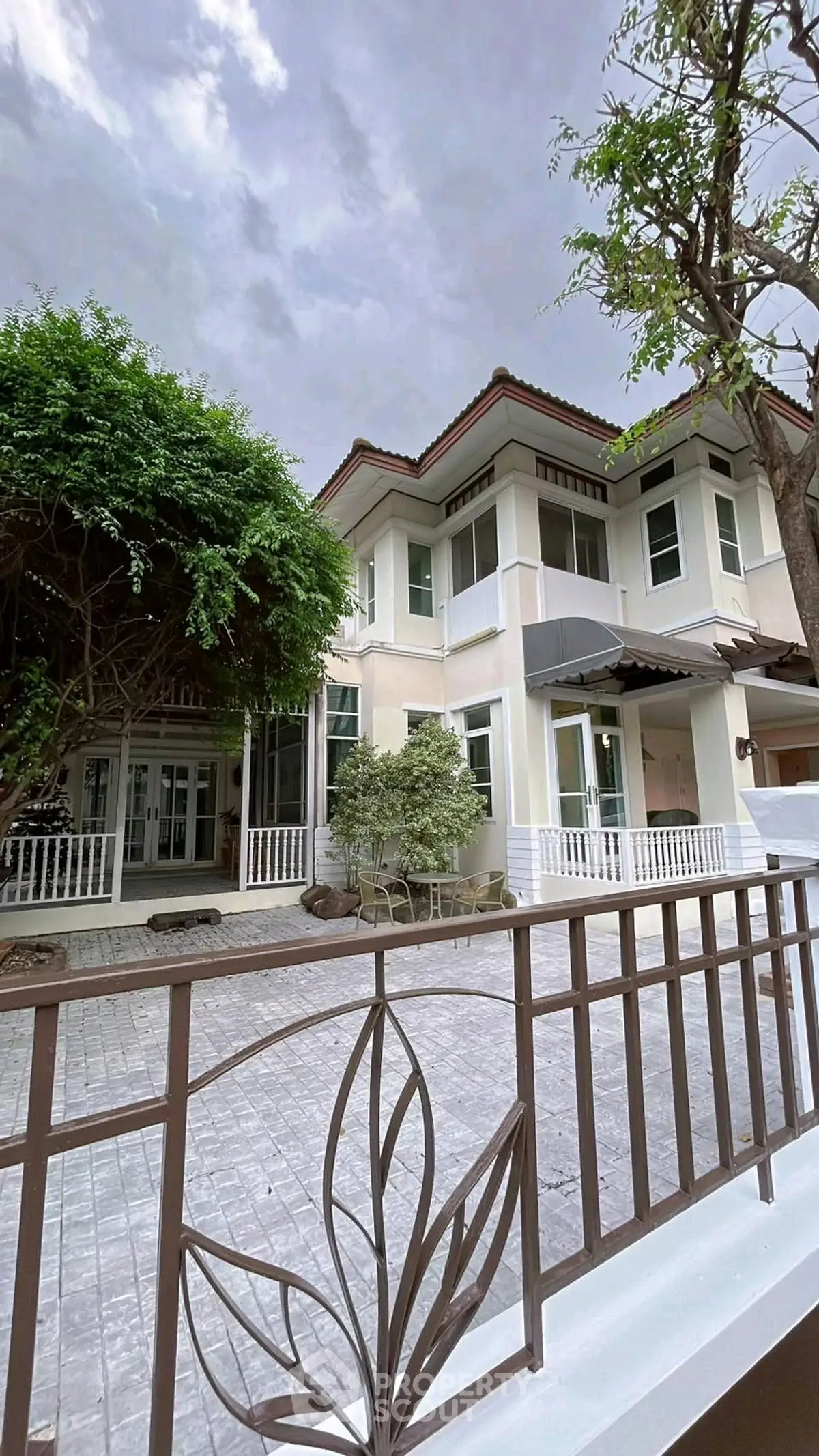 Elegant two-story house with lush greenery and spacious driveway, perfect for family living.