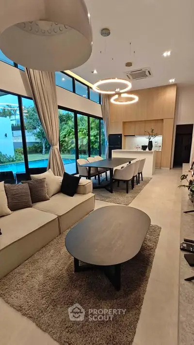 Luxurious open-plan living room with modern decor and pool view, perfect for entertaining.