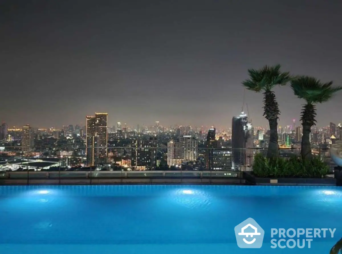 Stunning rooftop pool with breathtaking city skyline view at night