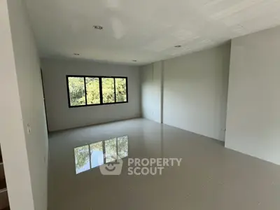 Spacious empty room with large window and glossy tiled floor