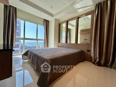 Luxurious bedroom with large windows offering stunning city views and elegant decor.