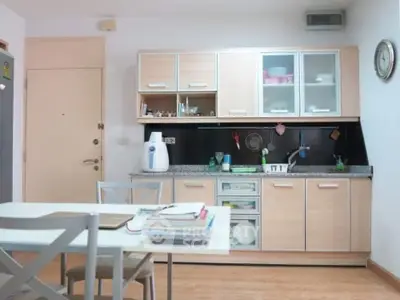 Modern kitchen with sleek cabinets and dining area in cozy apartment