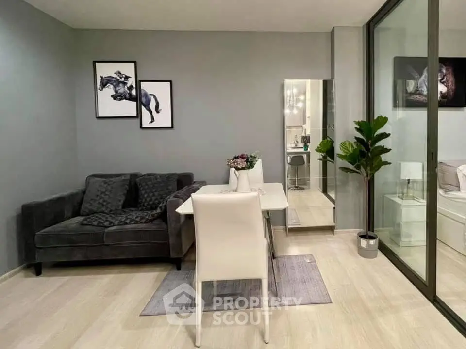 Modern living room with stylish decor and glass partition, featuring cozy seating and elegant dining area.