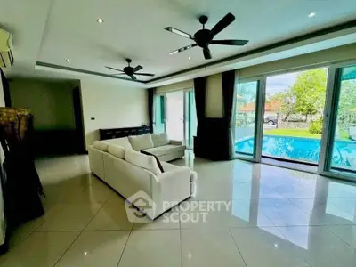 Spacious living room with pool view and modern ceiling fans