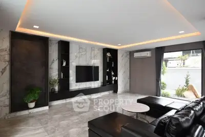 Luxurious modern living room with marble accents and sleek black furniture.