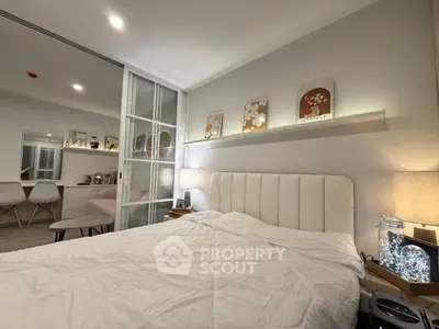 Cozy bedroom with modern decor and soft lighting, featuring a comfortable bed and stylish wall art.