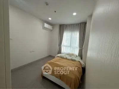 Cozy bedroom with modern decor and natural light in a stylish apartment.