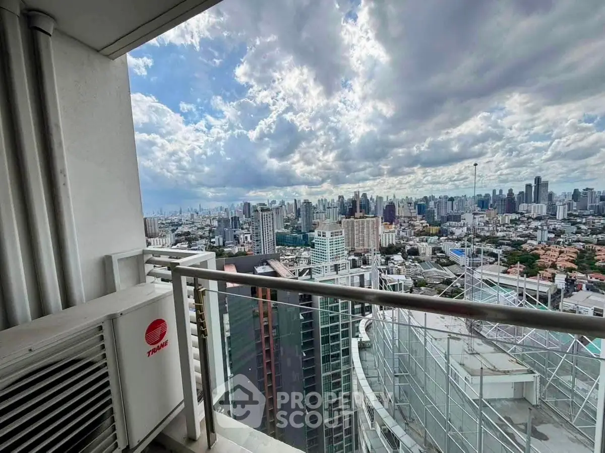 Stunning cityscape view from high-rise balcony with expansive skyline and dramatic clouds.