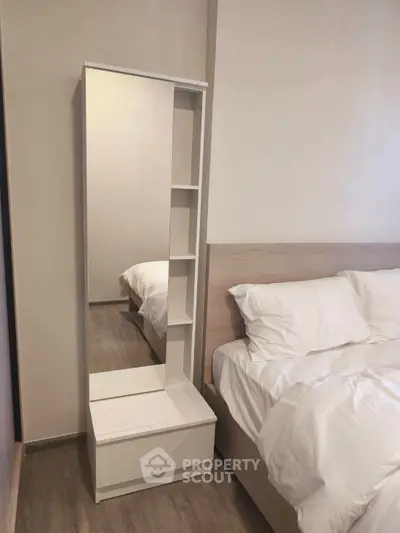 Modern bedroom with sleek white furniture and cozy bedding