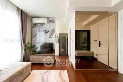 Modern living room with stylish decor, hardwood floors, and natural light.