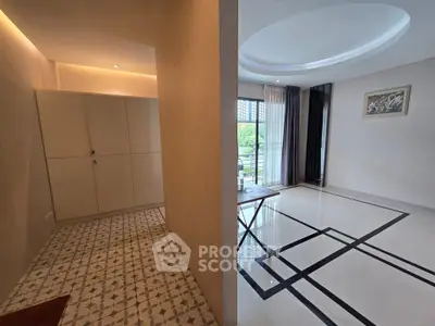 Modern living room with elegant flooring and balcony view in a stylish apartment.
