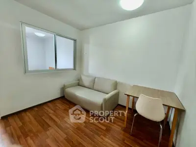Cozy minimalist living room with sofa and wooden table, perfect for small spaces.
