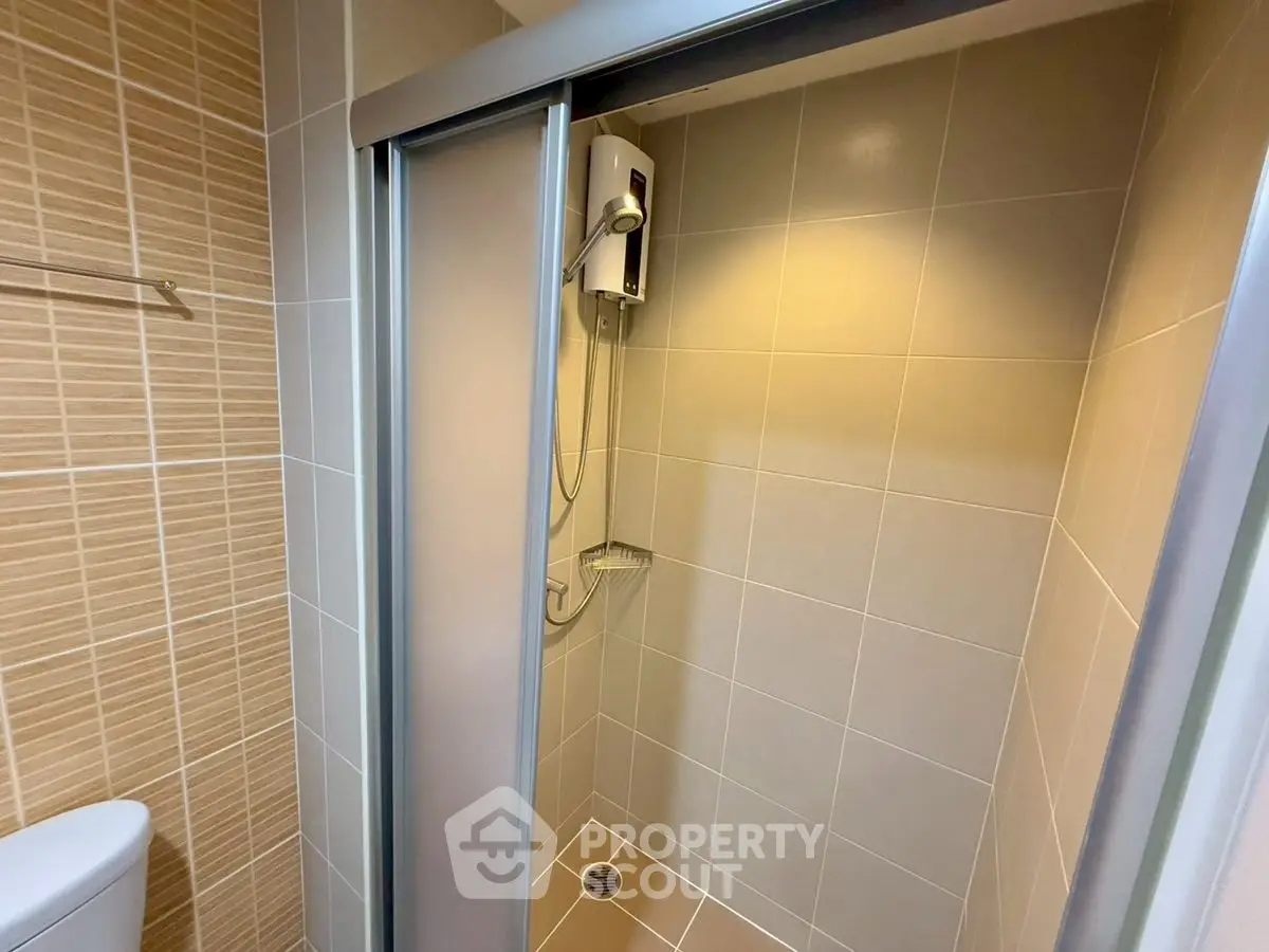 Modern bathroom with sleek shower enclosure and neutral tiles