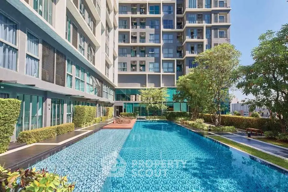 Luxurious modern apartment complex with stunning outdoor pool and lush greenery.