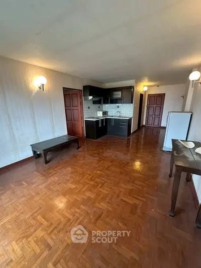 Spacious open-plan living area with wooden flooring and modern kitchen.