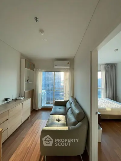 Modern apartment interior with cozy living room and bedroom, featuring large windows and stylish furniture.