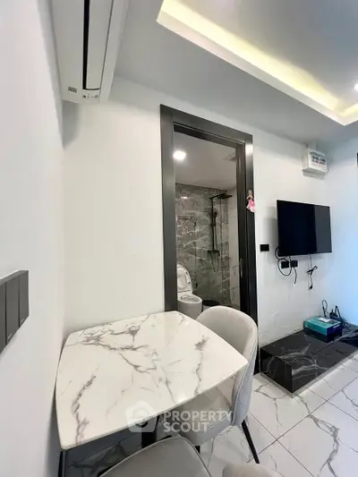 Modern apartment interior with marble table and wall-mounted TV