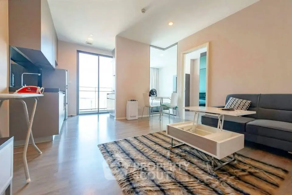 Modern living room with stylish decor and open kitchen layout in a bright apartment.