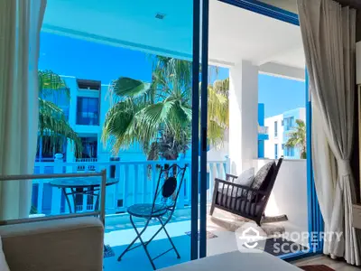 Luxurious balcony with a serene view, featuring comfortable seating and lush greenery, perfect for relaxation and enjoying the tropical ambiance.