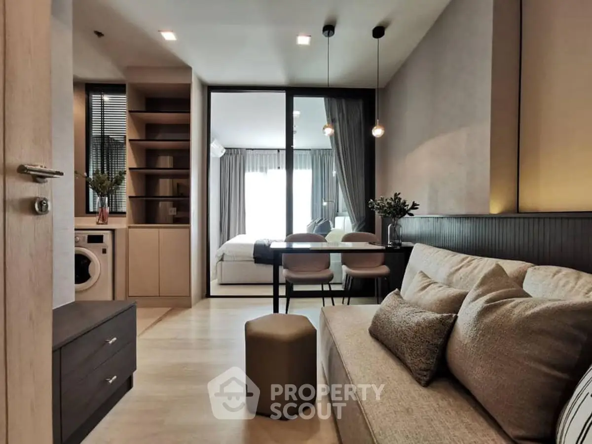 Modern open-plan living room with cozy sofa and dining area, featuring a stylish bedroom view.