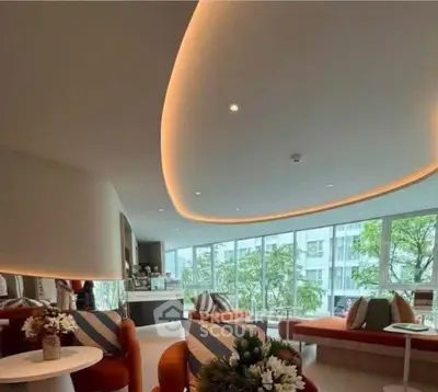 Modern living room with stylish lighting and large windows overlooking greenery.