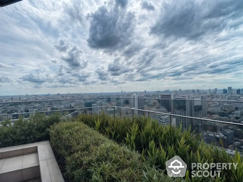 Stunning cityscape view from a high-rise balcony with lush greenery and dramatic sky.