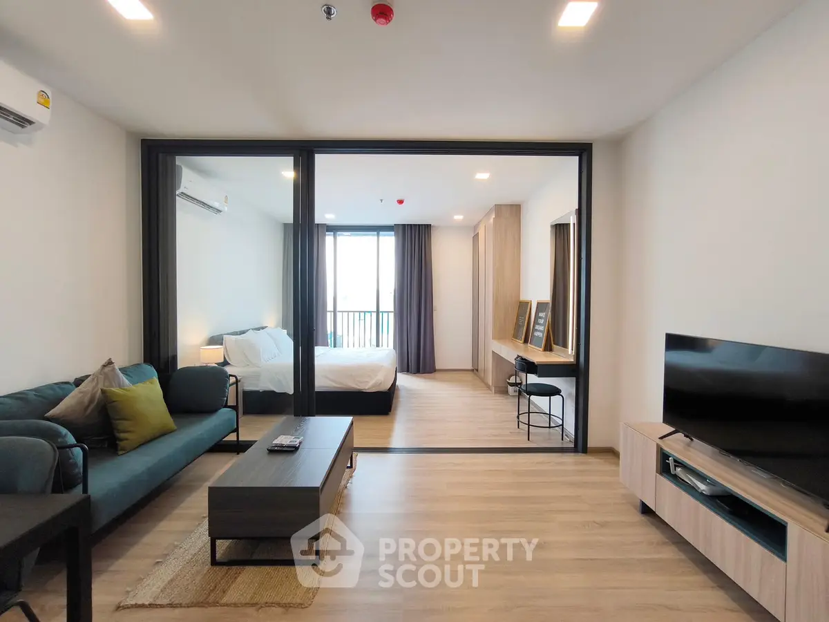 Modern open-plan living room with stylish furniture and bedroom view