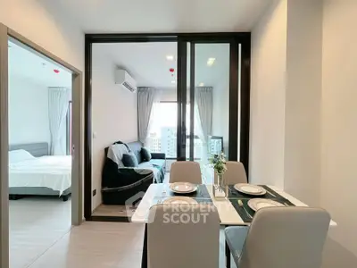 Modern apartment with open living and dining area, featuring stylish decor and city view.