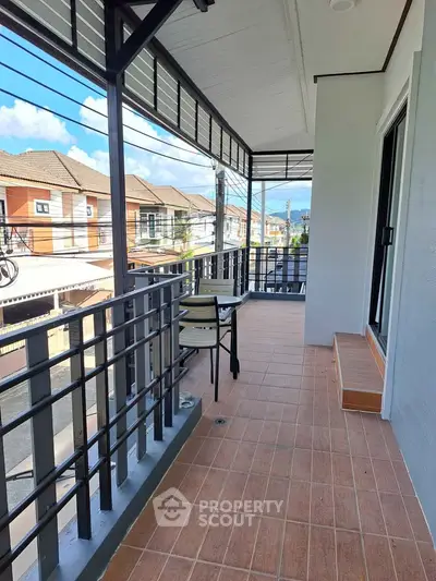 Spacious balcony with seating and scenic neighborhood view, perfect for relaxation and outdoor enjoyment.