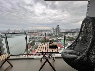 Stunning cityscape view from a high-rise balcony with cozy seating.