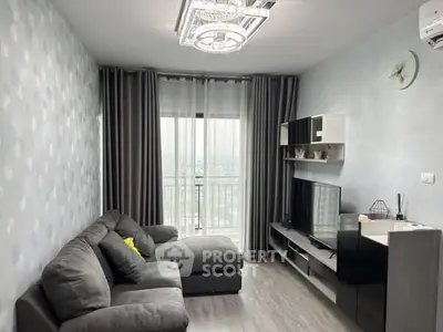 Modern living room with gray sofa, stylish decor, and large window with city view.