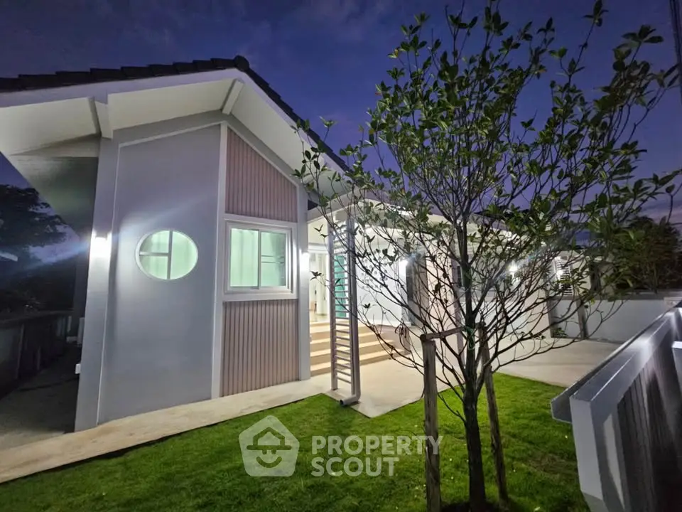 Modern house exterior with lush garden and unique architectural design at dusk.