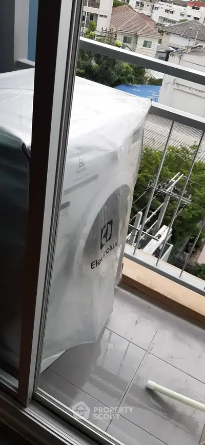 Modern balcony with washing machine and city view, perfect for urban living convenience.