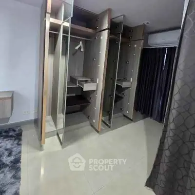 Spacious modern wardrobe with mirrored doors in a sleek bedroom setting.
