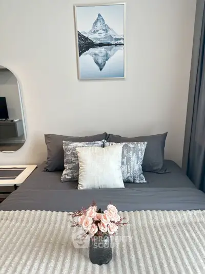 Elegant bedroom with stylish decor and mountain artwork above bed